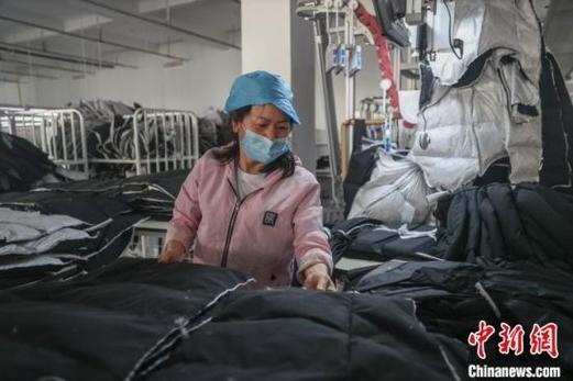 图为11月12日,位于共青城的"鸭鸭"智能制造标准化样板工厂内,工人正在